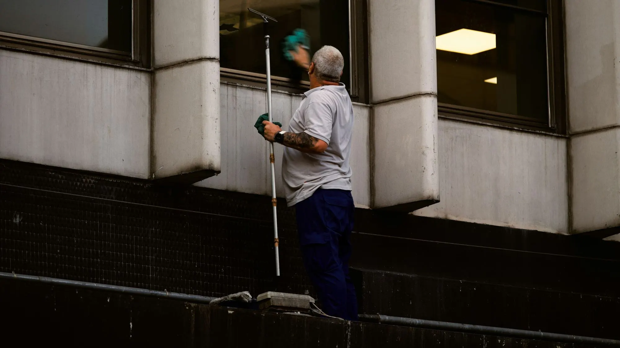 Fensterreiniger säubert Fenster an einer Gebäudefassade